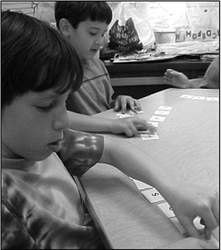 First-grade immersion students from Nitrauer Elementary School work  
					 on making syllables from letter combinations.